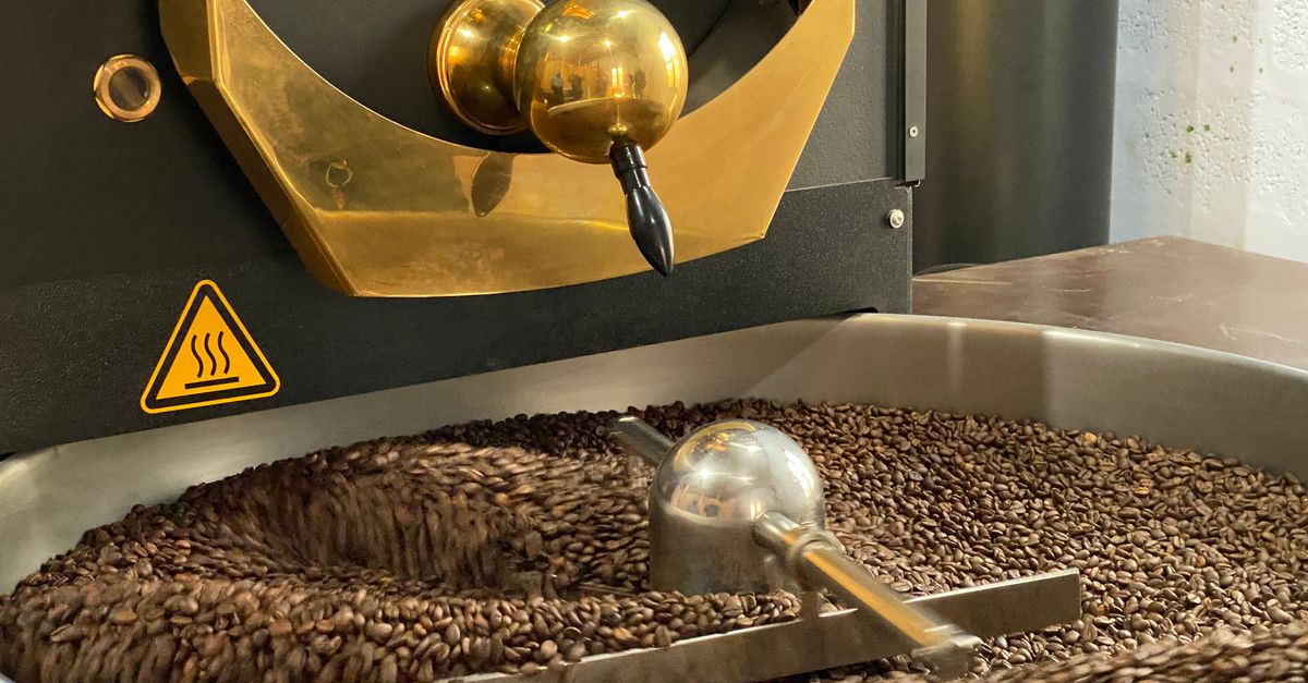 Close-up of coffee beans being roasted in a Probat industrial coffee roaster.