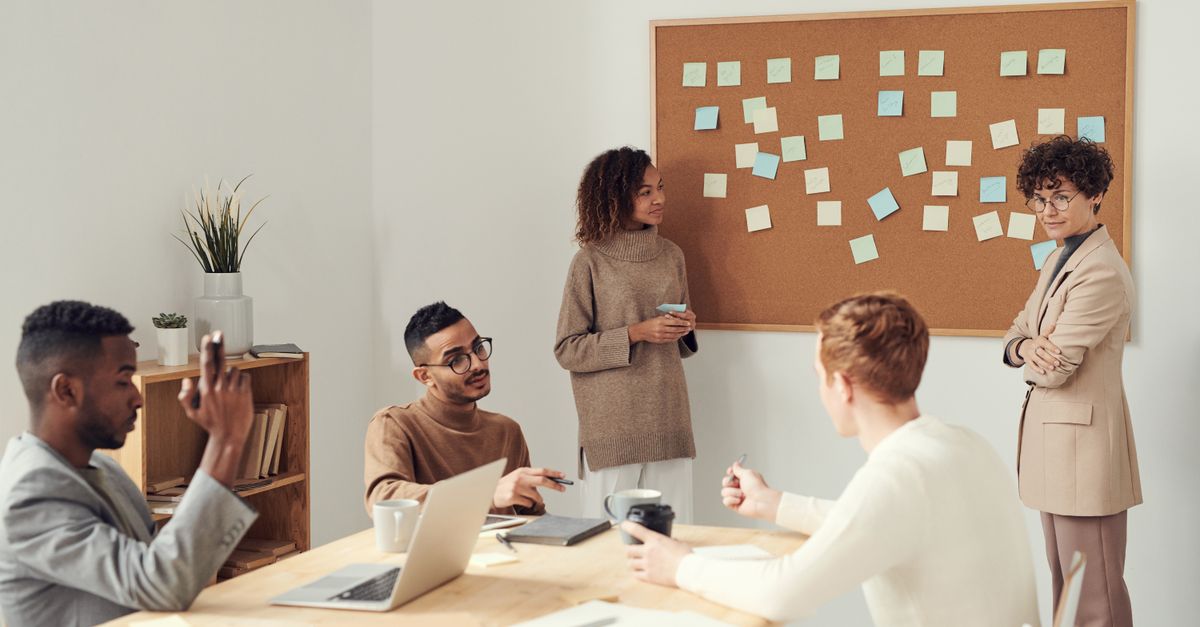 A diverse group of professionals collaborating in a modern office setting with a brainstorming session.