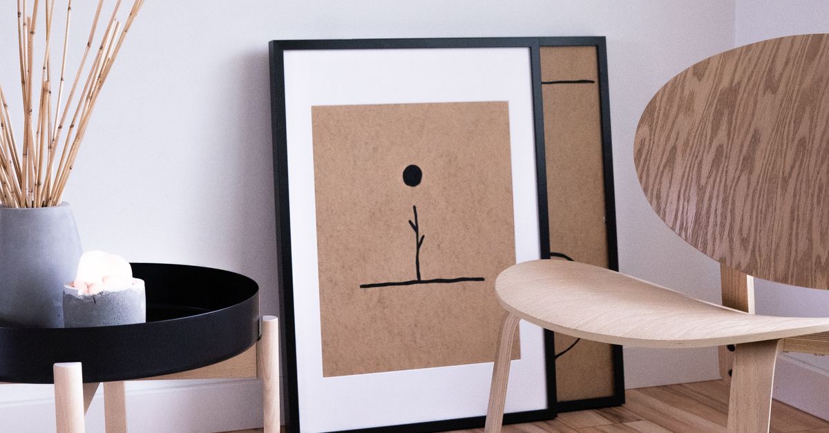 A serene Japandi style room with minimalist wooden furniture and abstract art on display.